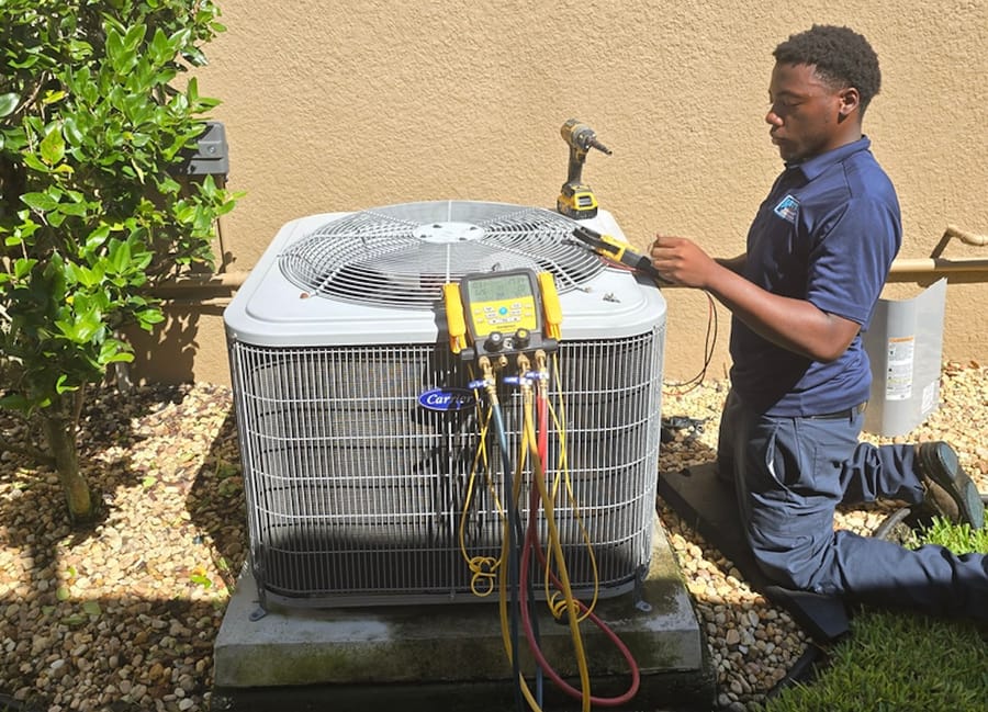 Technician conducting maintenance on an AC unit.