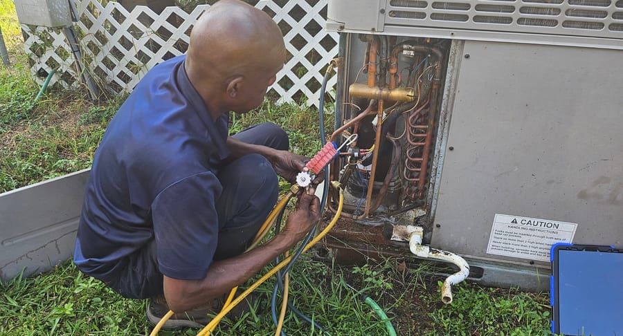 Technician repairing HVAC unit.