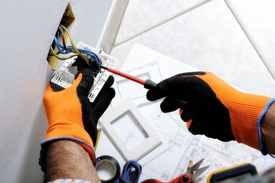 Electrician working safely on switches and outlets of a residential electrical system