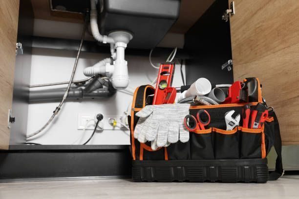 plumbing bag with tools below a sink